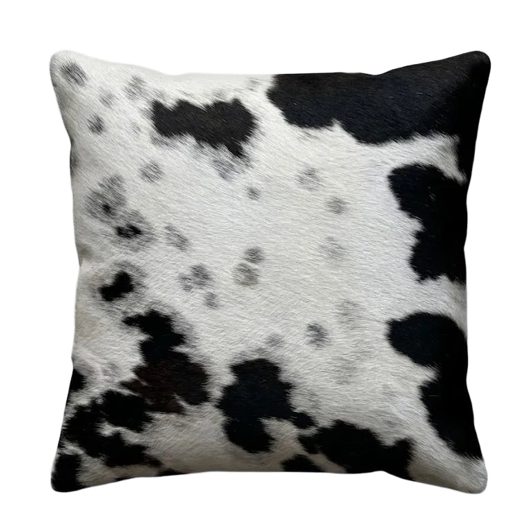 A square cushion with a black and white cowhide pattern.