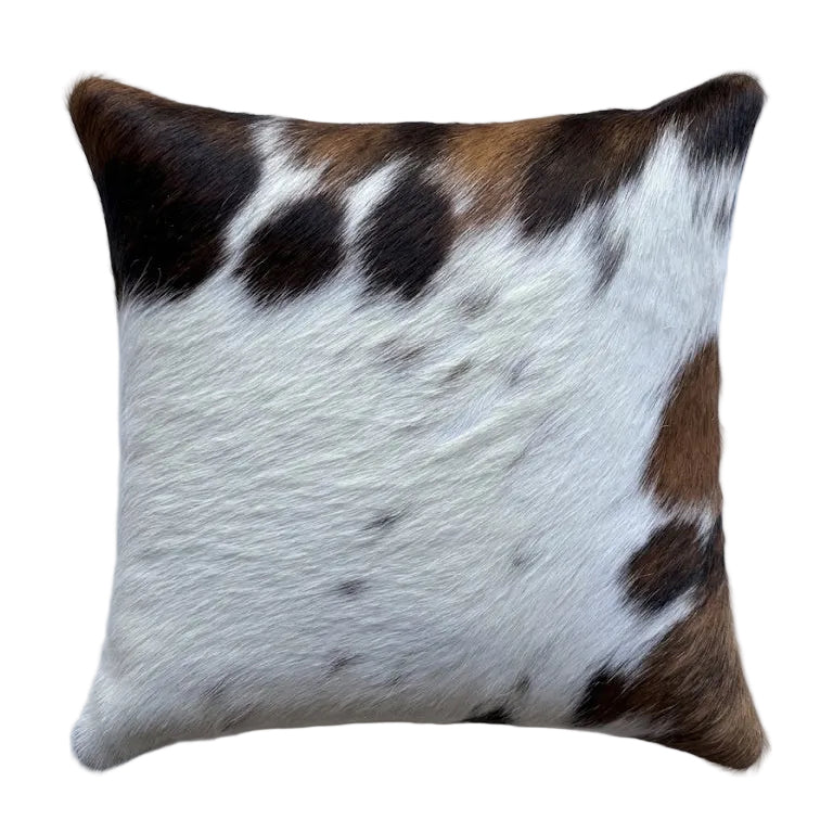 A square cushion with a brown and white and black cowhide pattern.