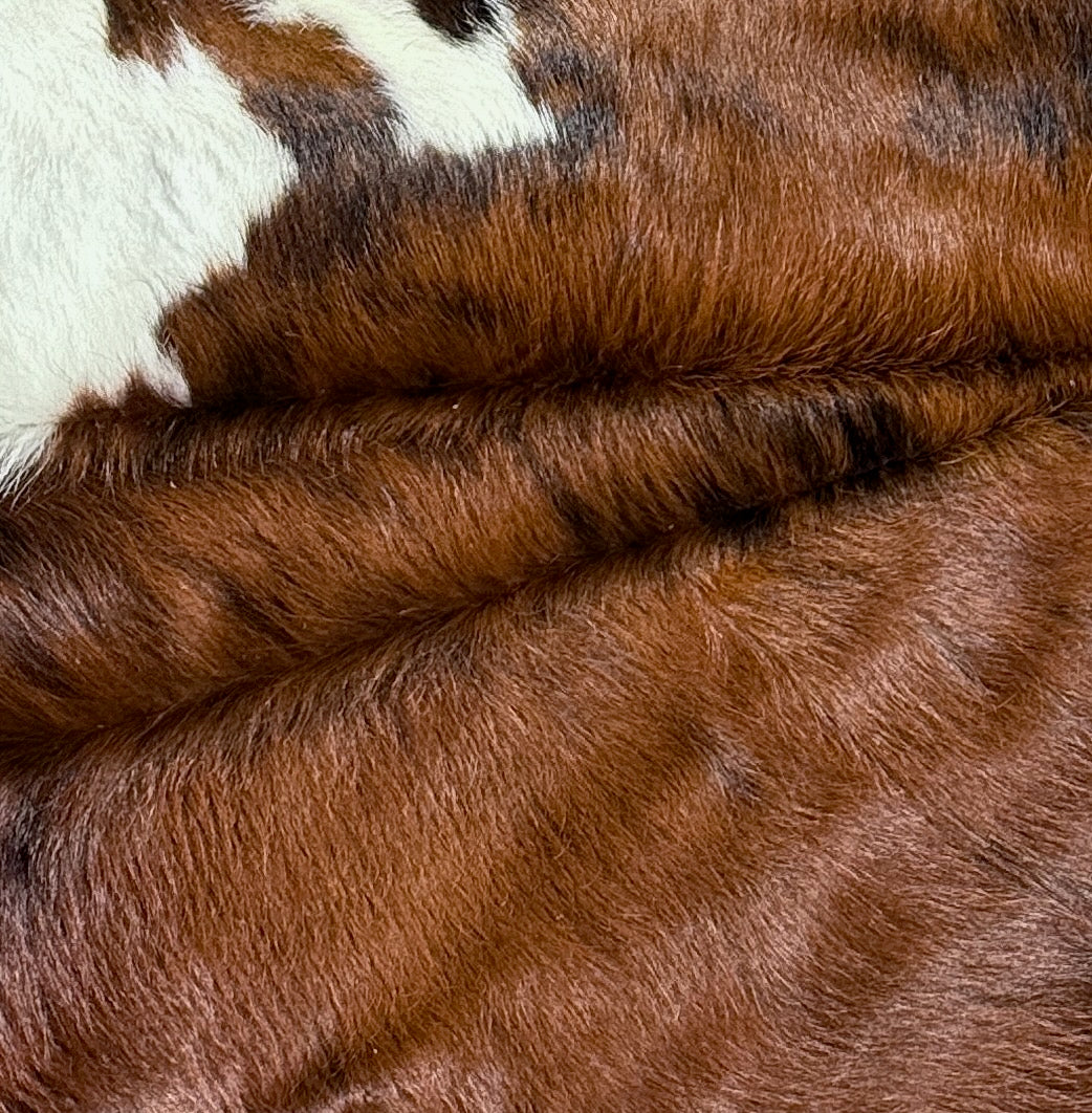 Premium cowhide rug in natural black and white, measuring 180cm by 165cm, showcasing the leather's unique pattern and texture.