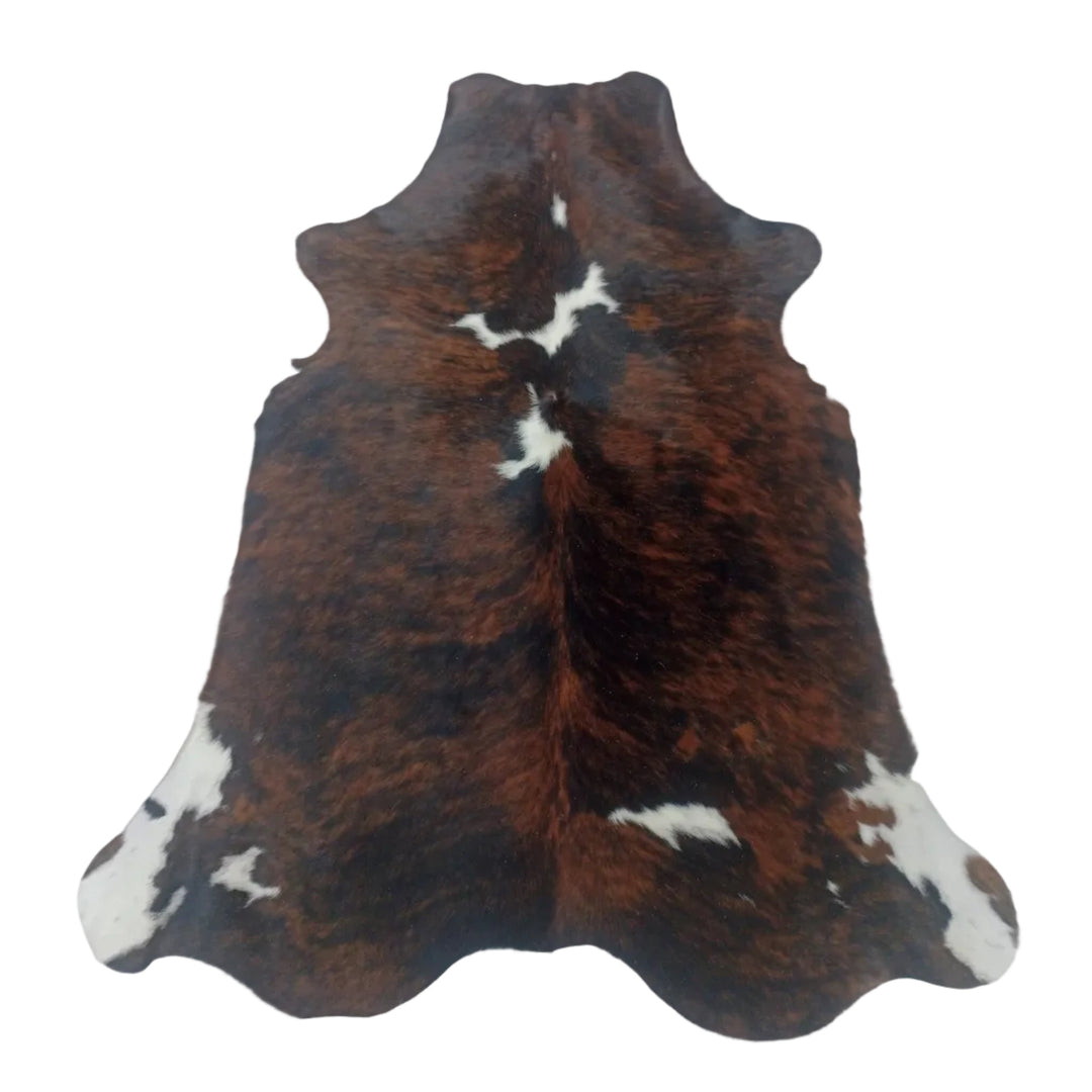 A natural cowhide rug with a brown, black, and white 