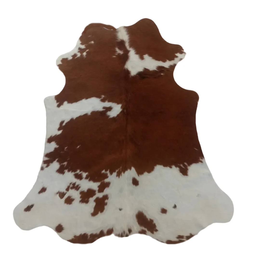 Brown and white cowhide rug on a white background