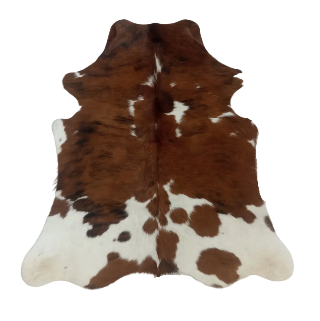 Brown and white cowhide rug laid flat on a white  surface.