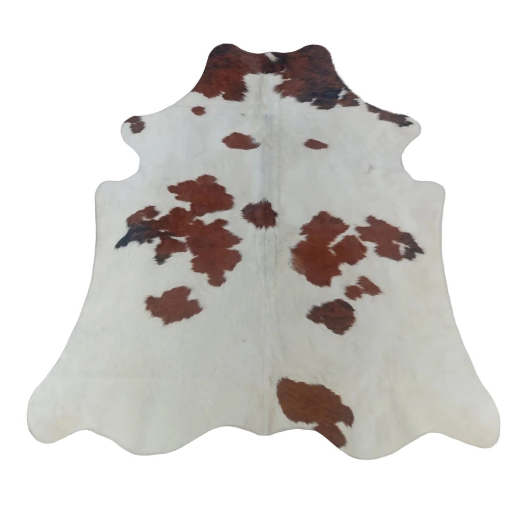 A natural cowhide rug with a brown and black spotted pattern on an off-white base.
