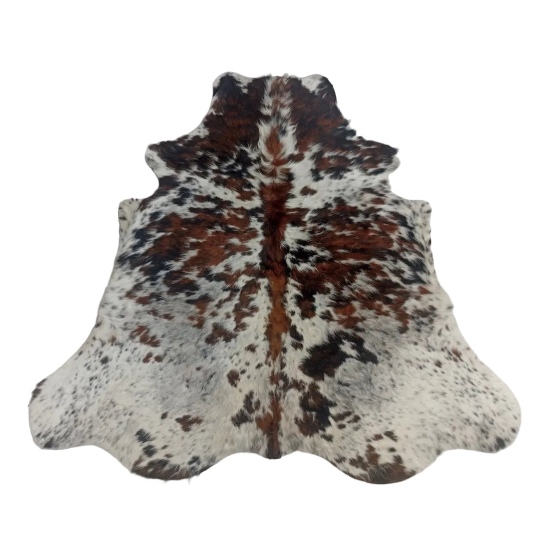 A natural cowhide rug with a brown, black, and white spotted pattern,