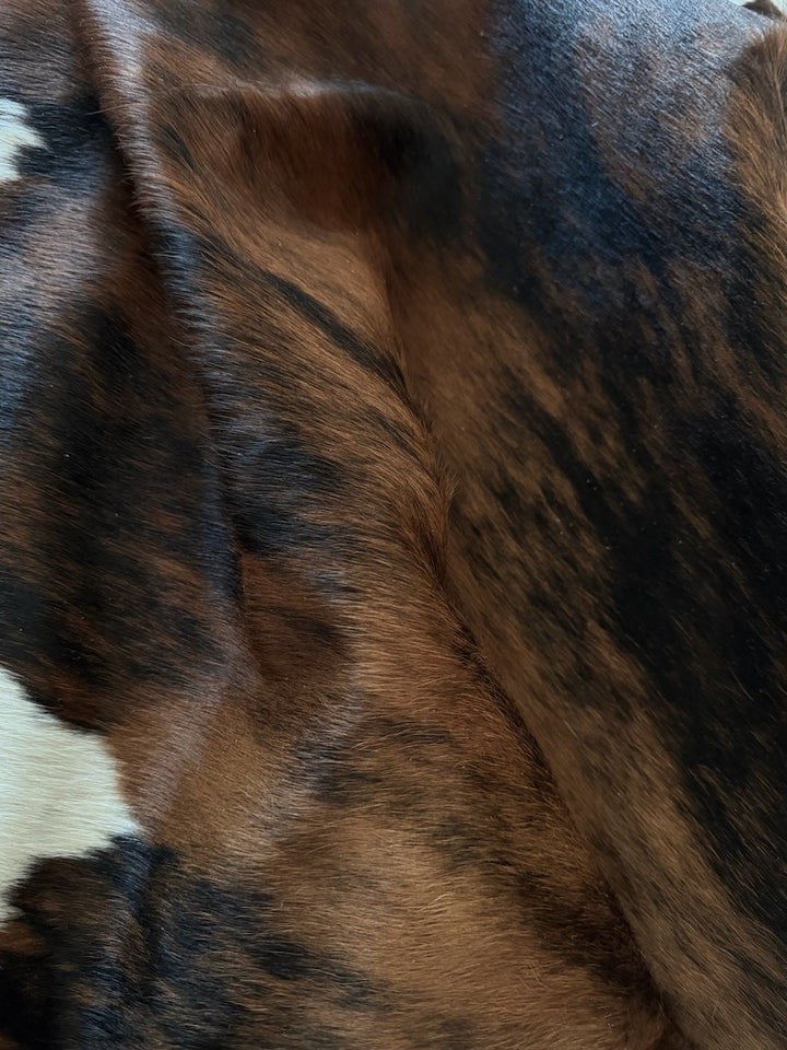 Close-up of a cowhide rug with brown, black, and white colours.