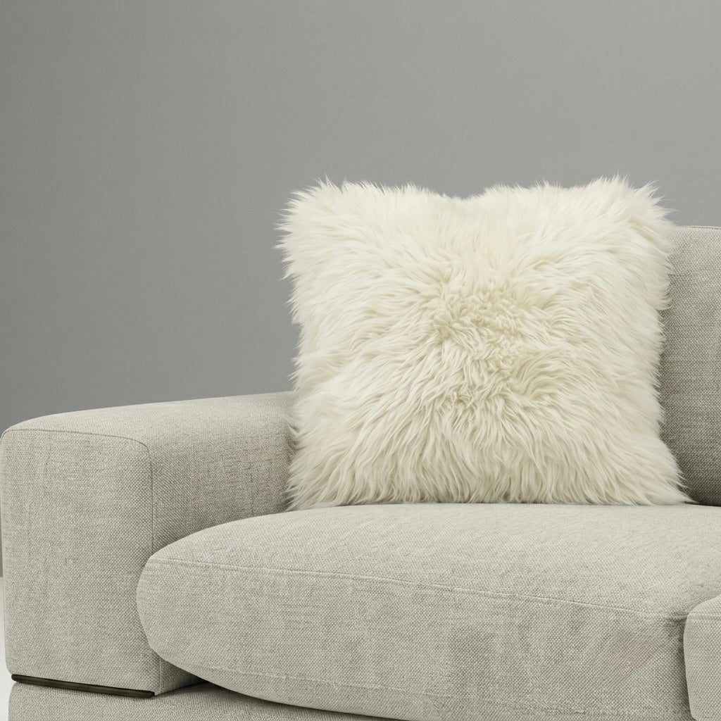 Gray sofa with a sheepskin cushion/ pillow against a gray background