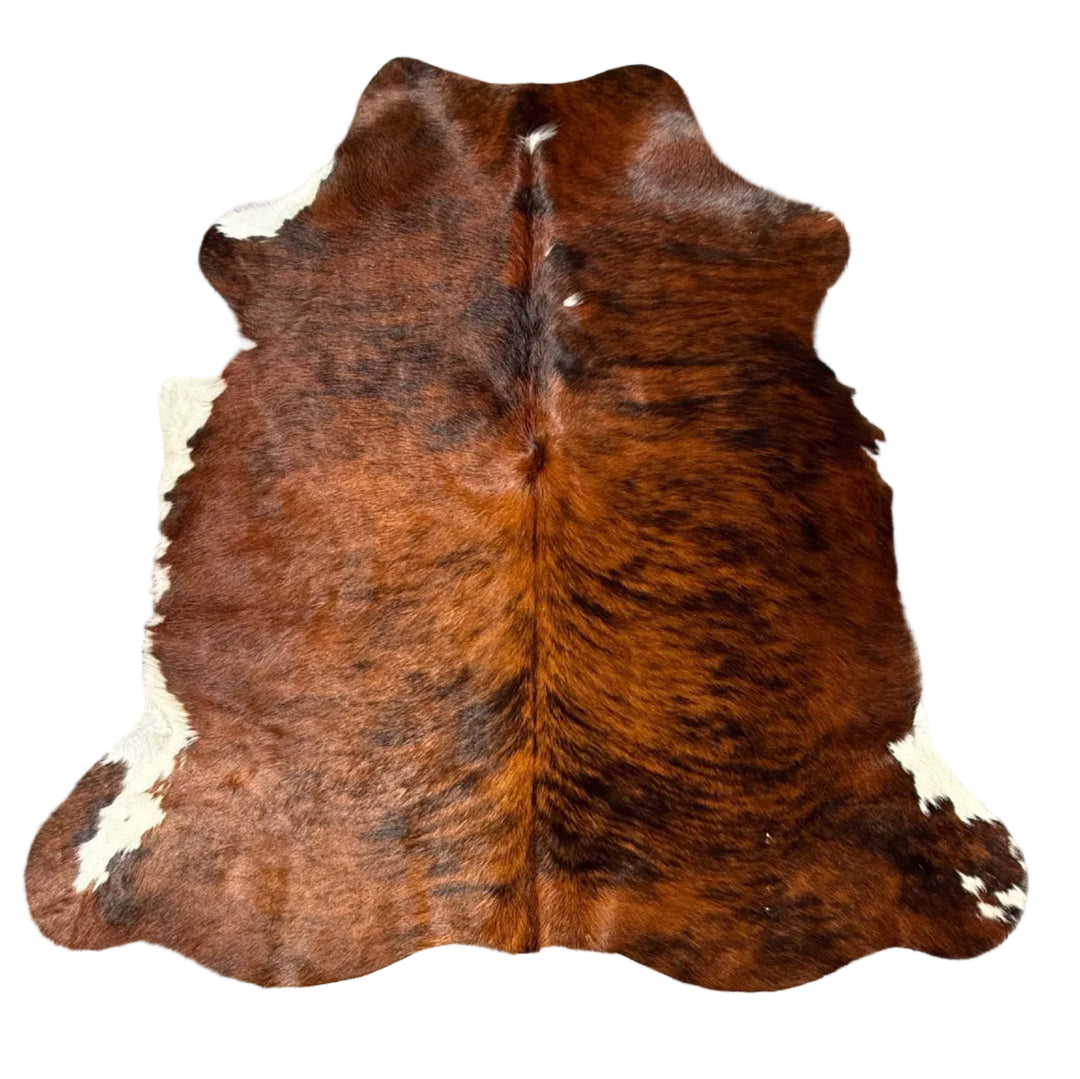 Brown and white cowhide rug laid flat