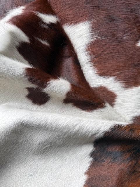 Large cowhide rug from Cowhide Rugs London, natural premium cowhide with a H58 pattern, measuring 250cm by 220cm.