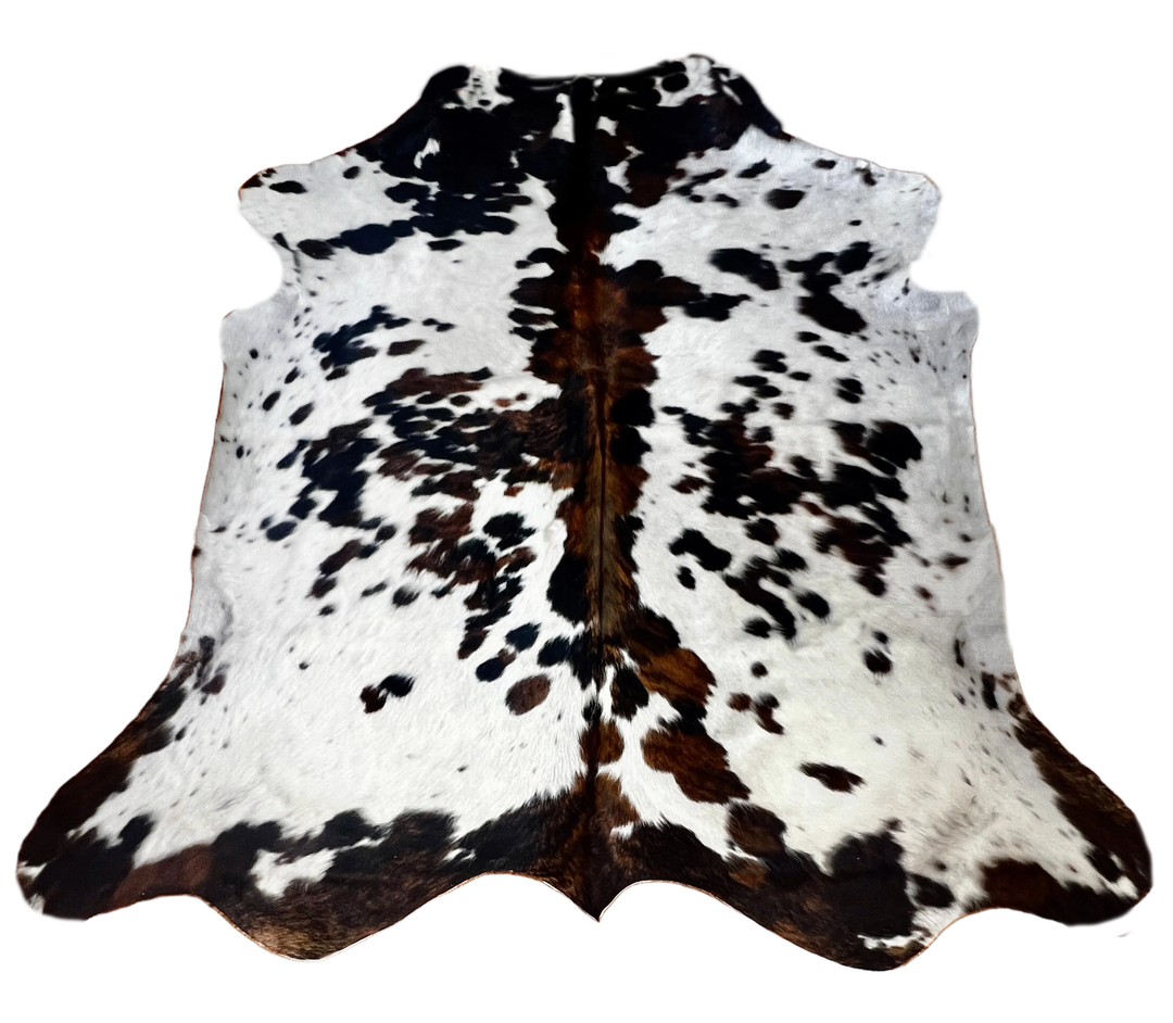 A natural cowhide rug with a black and brown spotted pattern on a white base.