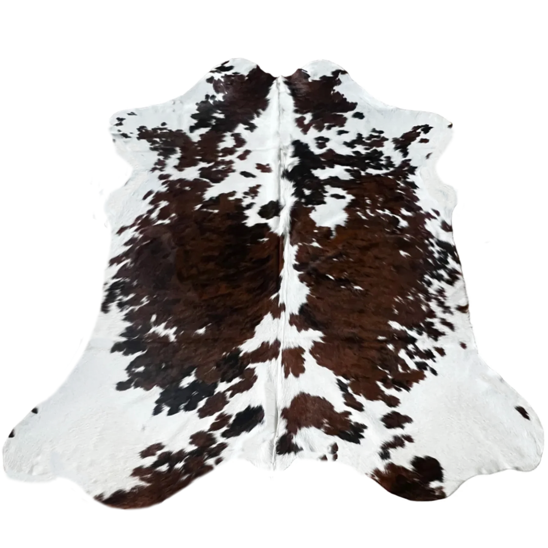 A natural cowhide rug with a classic black and brown spotted pattern on a white base.