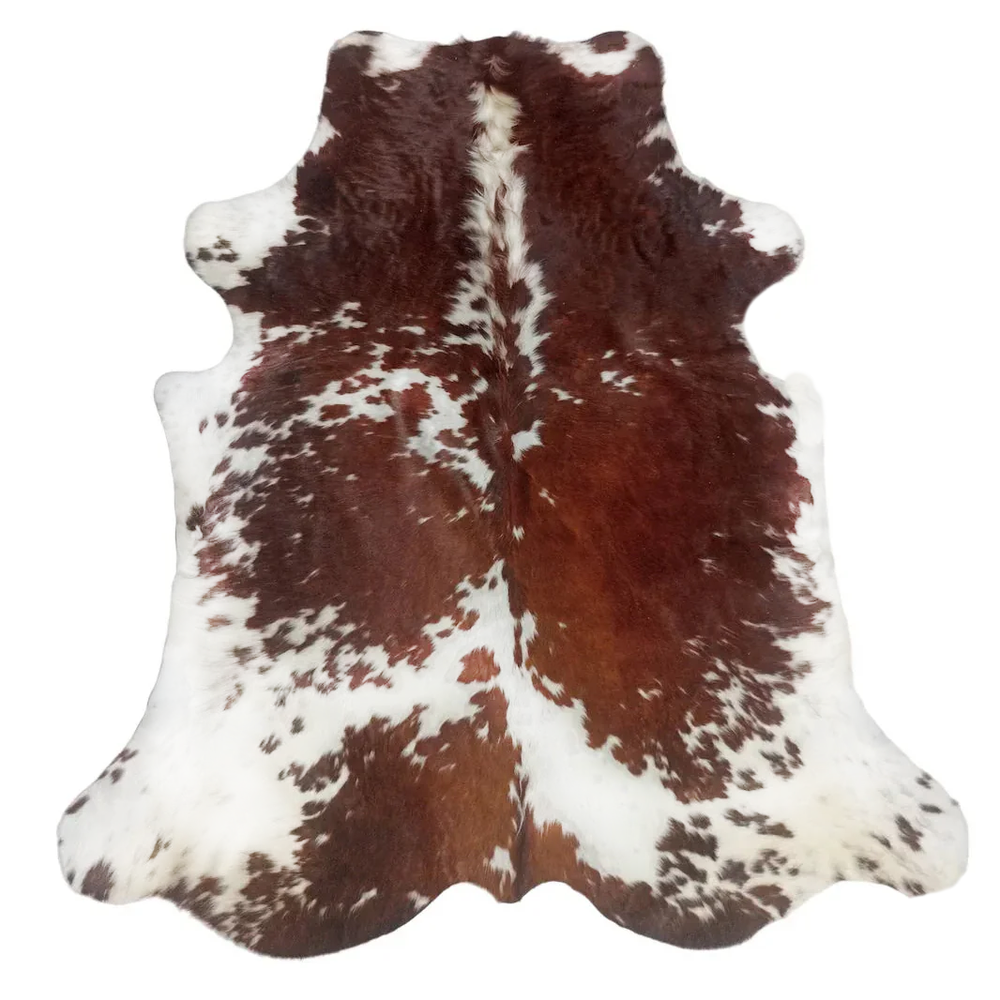 Brown and white cowhide rug with a natural hair-on-hide pattern, photographed flat against a white background.