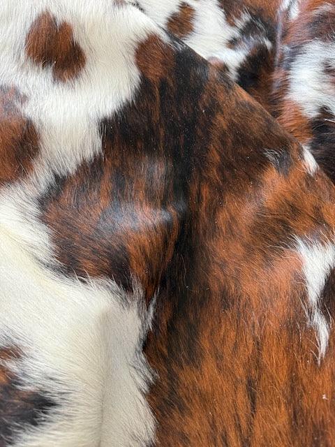 Premium cowhide rug from Cowhide Rugs London, large 230cm x 208cm natural cowhide with distinctive markings and soft texture.