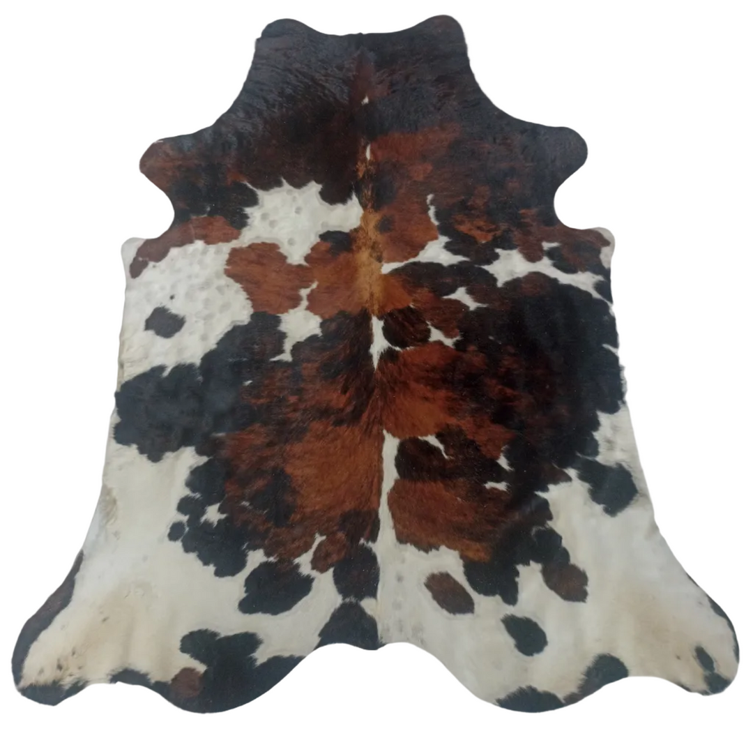 A natural cowhide rug with a mottled pattern of black, brown, and cream patches