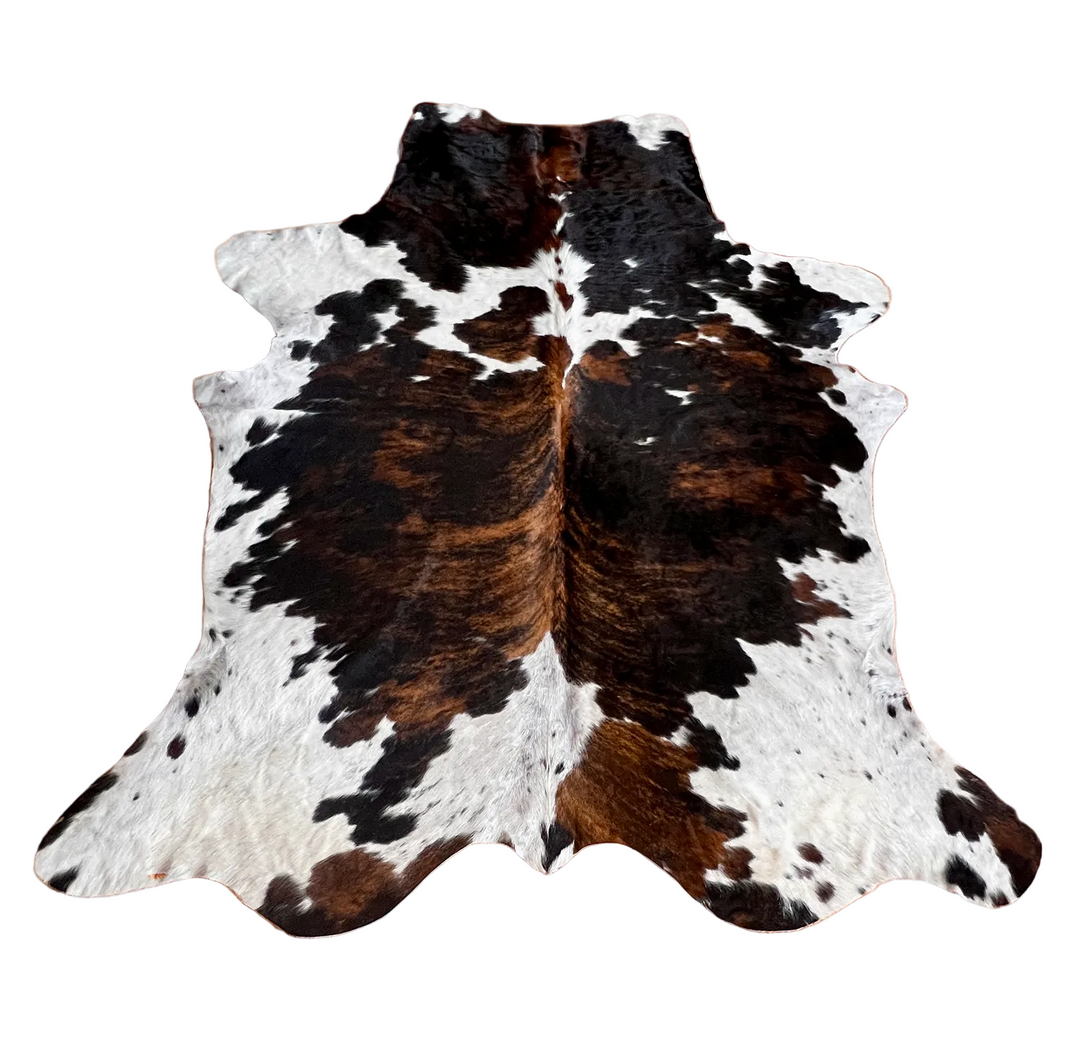 Large cowhide rug from Cowhide Rugs London, 213cm x 186cm, with natural brown and white patches, stylish and durable decor piece.