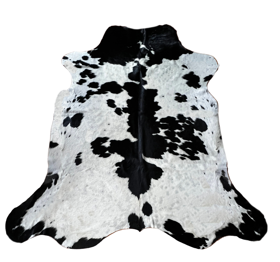 Black and white cowhide rug with a natural spotted pattern,