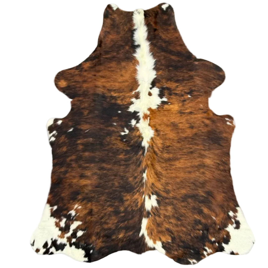 Brown and white cowhide rug laid flat 