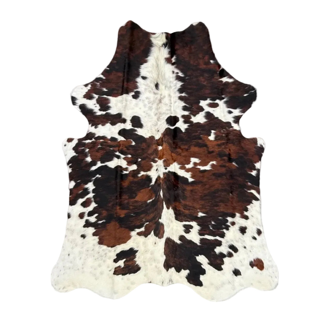Brown and white cowhide rug laid flat