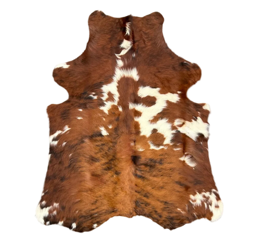 A natural cowhide rug with a brown and white spotted pattern