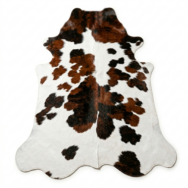 Cowhide rug with brown, black, and white pattern on a white background