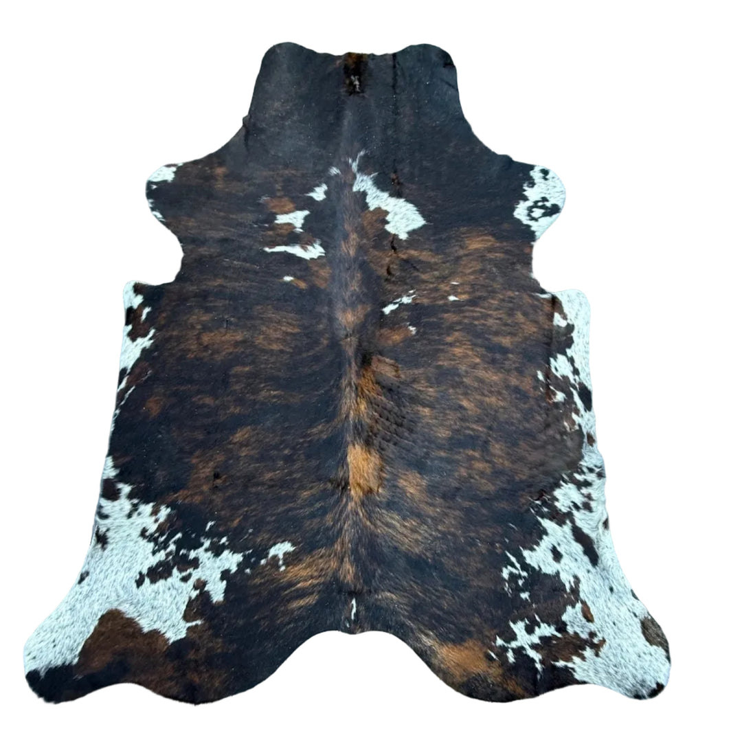 A natural cowhide rug with a brown, black, and white mottled pattern, l