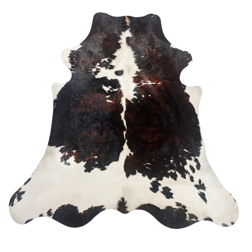 A natural brown black and white cowhide rug with a distinctive brown center stripe, displayed flat against a white background.