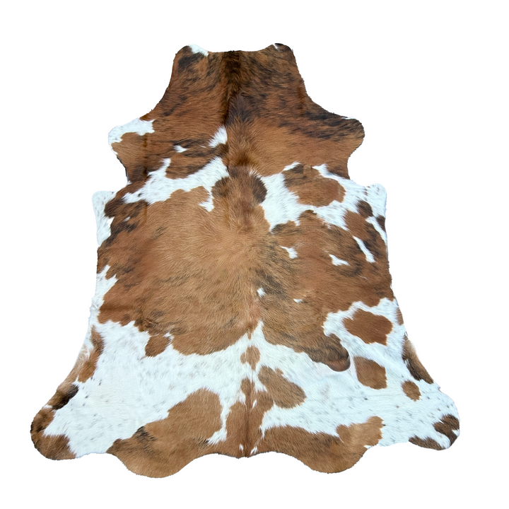 Brown and white cowhide rug with natural mottled pattern, photographed flat against a solid white background.