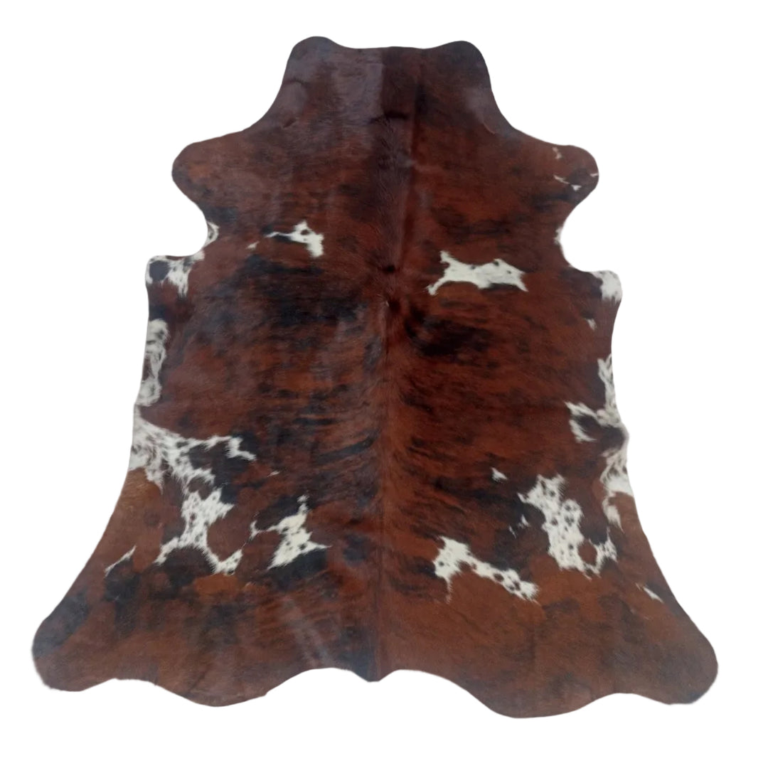 A natural cowhide rug with a brown, black, and white spotted pattern, 