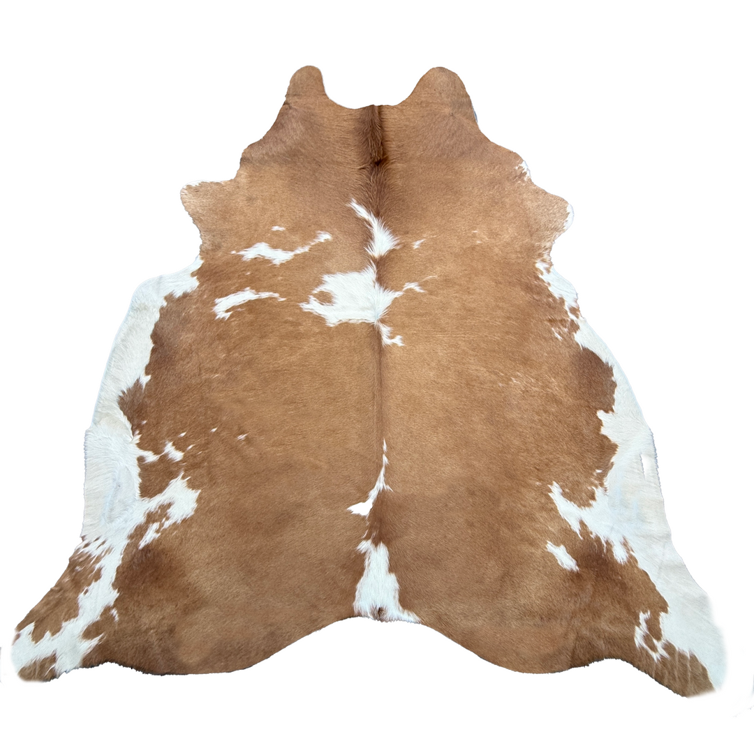 Brown and white cowhide rug on a white background
