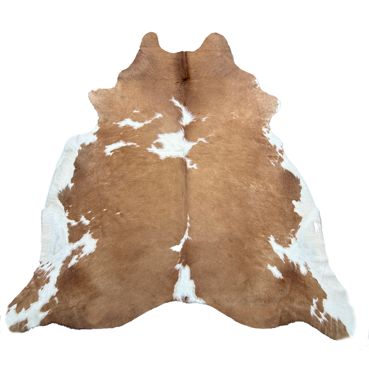 Brown and white cowhide rug on a white background
