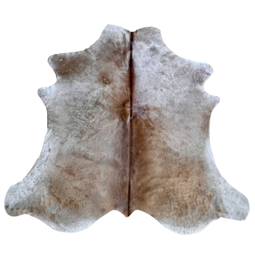 A natural cowhide rug with an irregular hide shape, featuring a mottled pattern of light gray, beige, and brown tones, 