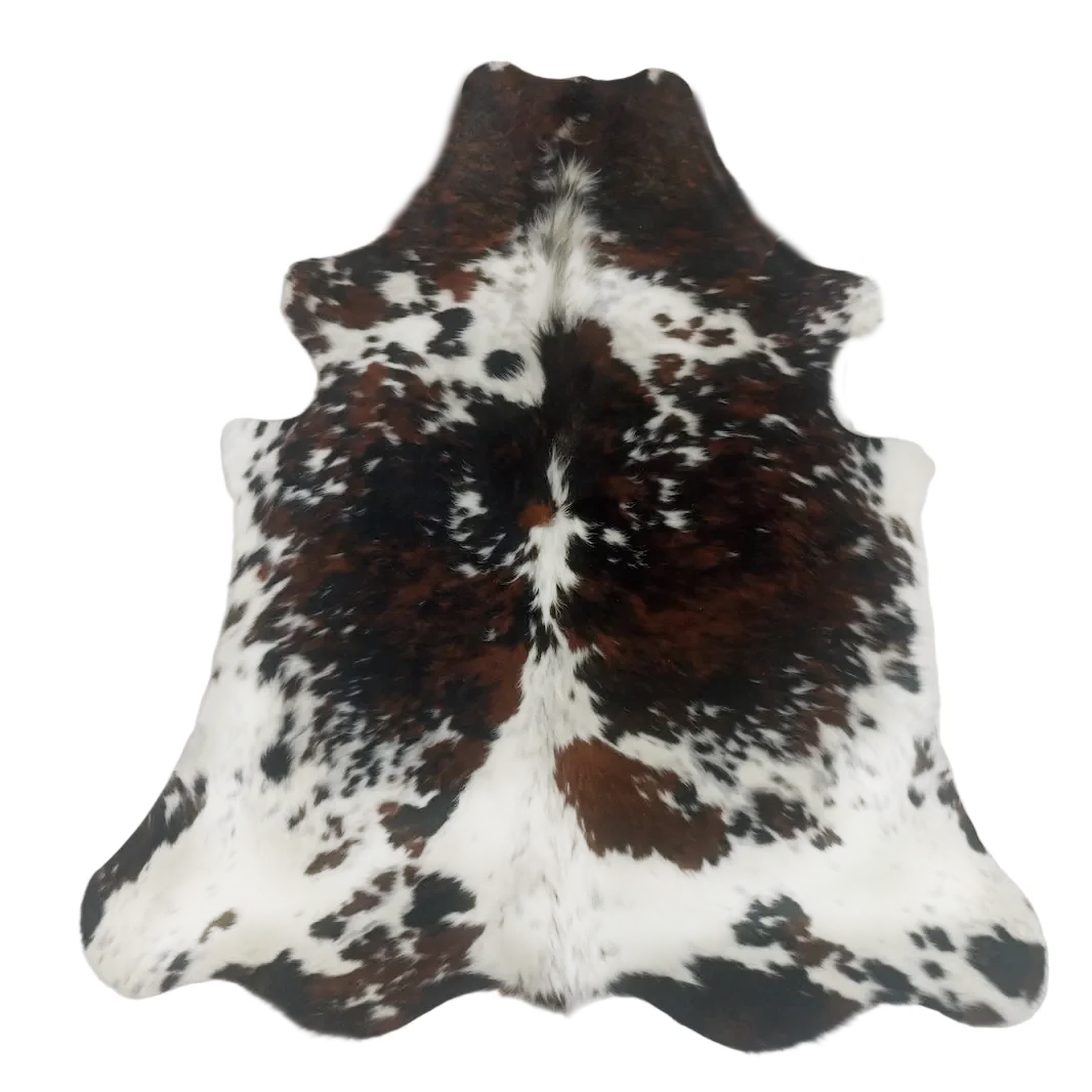 Tricolor cowhide rug with brown, black, and white pattern on a white background