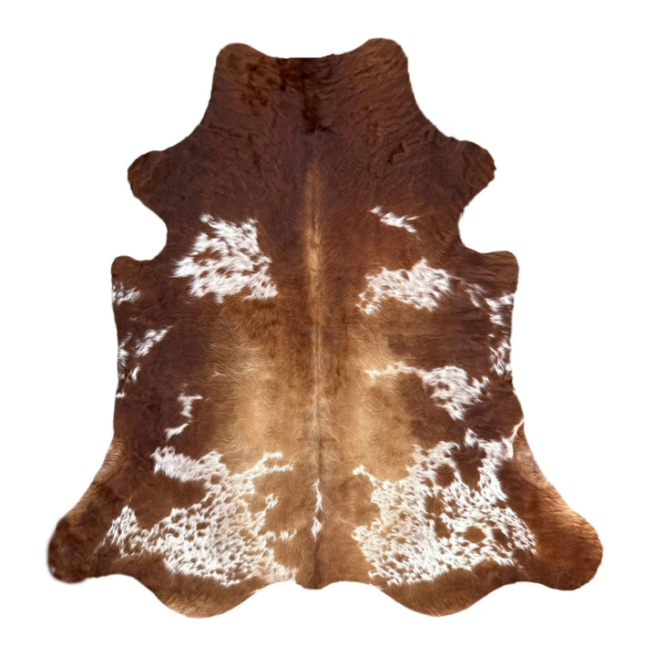 High-quality, genuine cowhide rug in rich caramel brown and white speckles, featuring a prominent natural spine line and a speckled salt-and-pepper pattern toward the bottom edge.