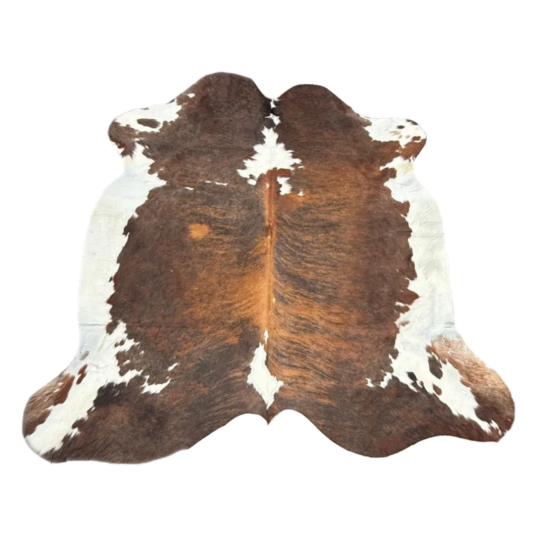 A natural cowhide rug with a brown and white mottled pattern.