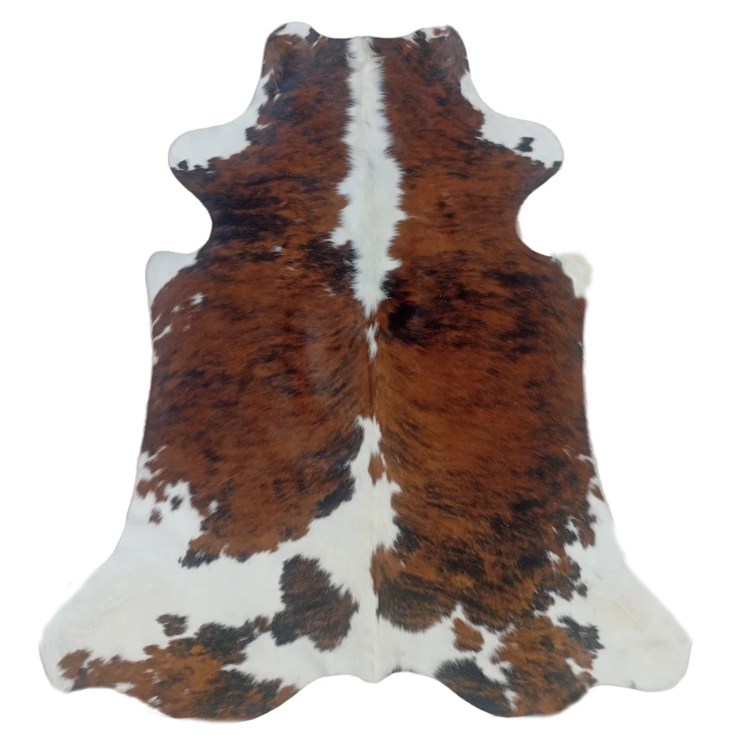 Cowhide rug with brown, black, and white pattern on a white background