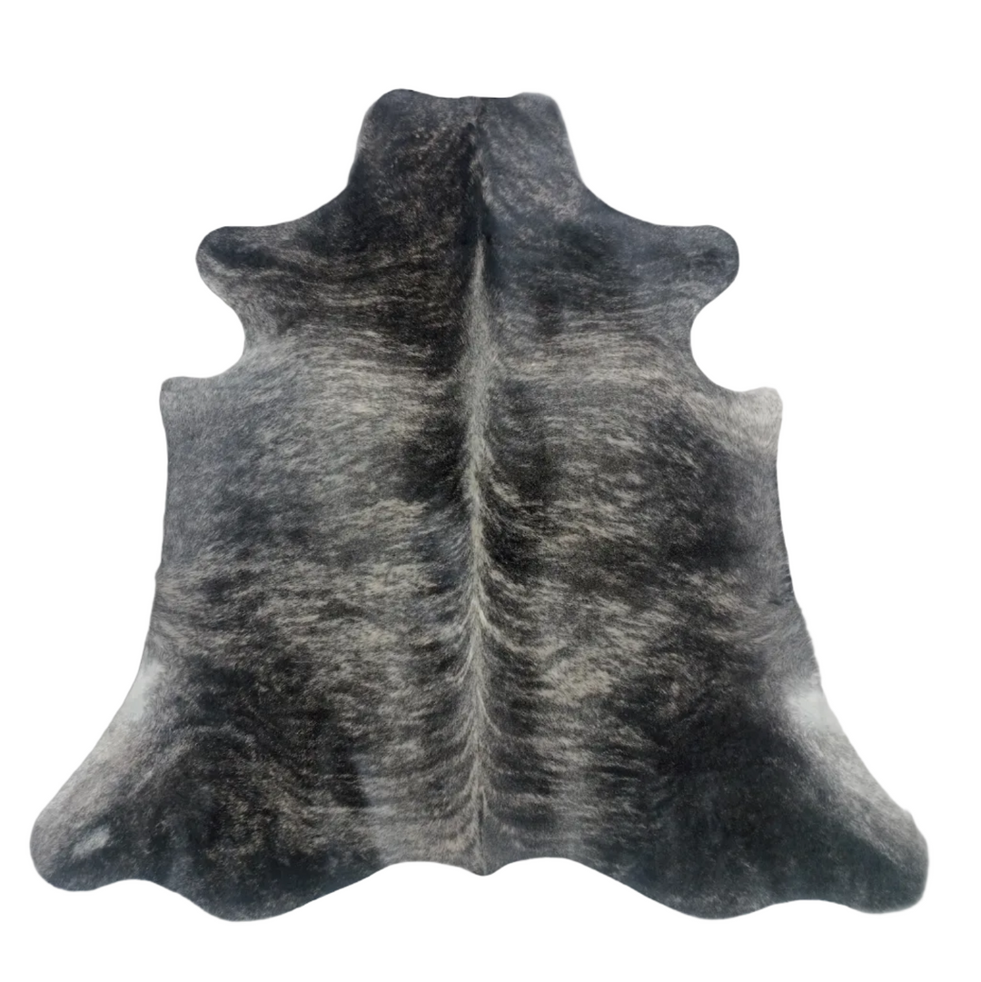 A natural cowhide rug with a black and white mottled pattern