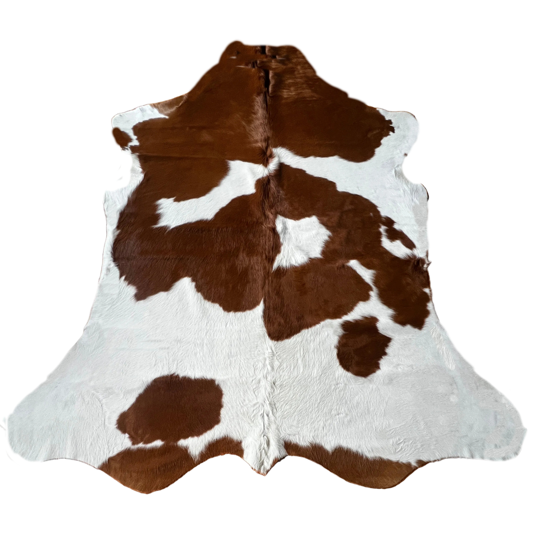 Brown and white cowhide rug with natural irregular patches and a short-pile texture, 