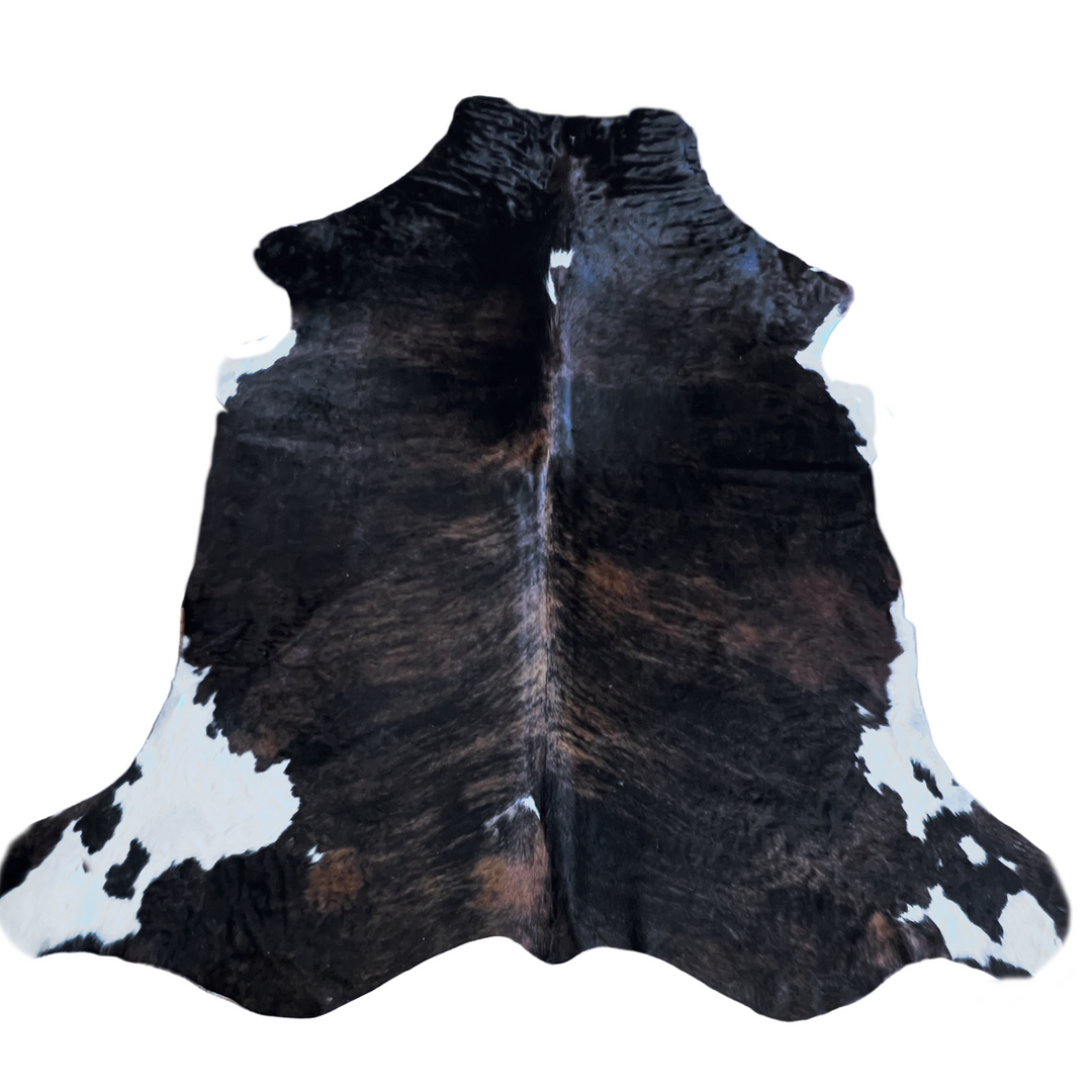 A natural black and white cowhide rug with brown undertones.