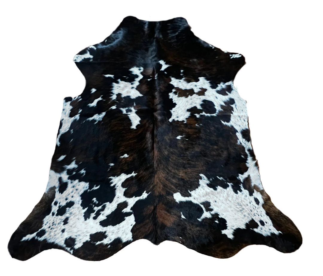 A black brown and white cowhide rug with a natural mottled pattern