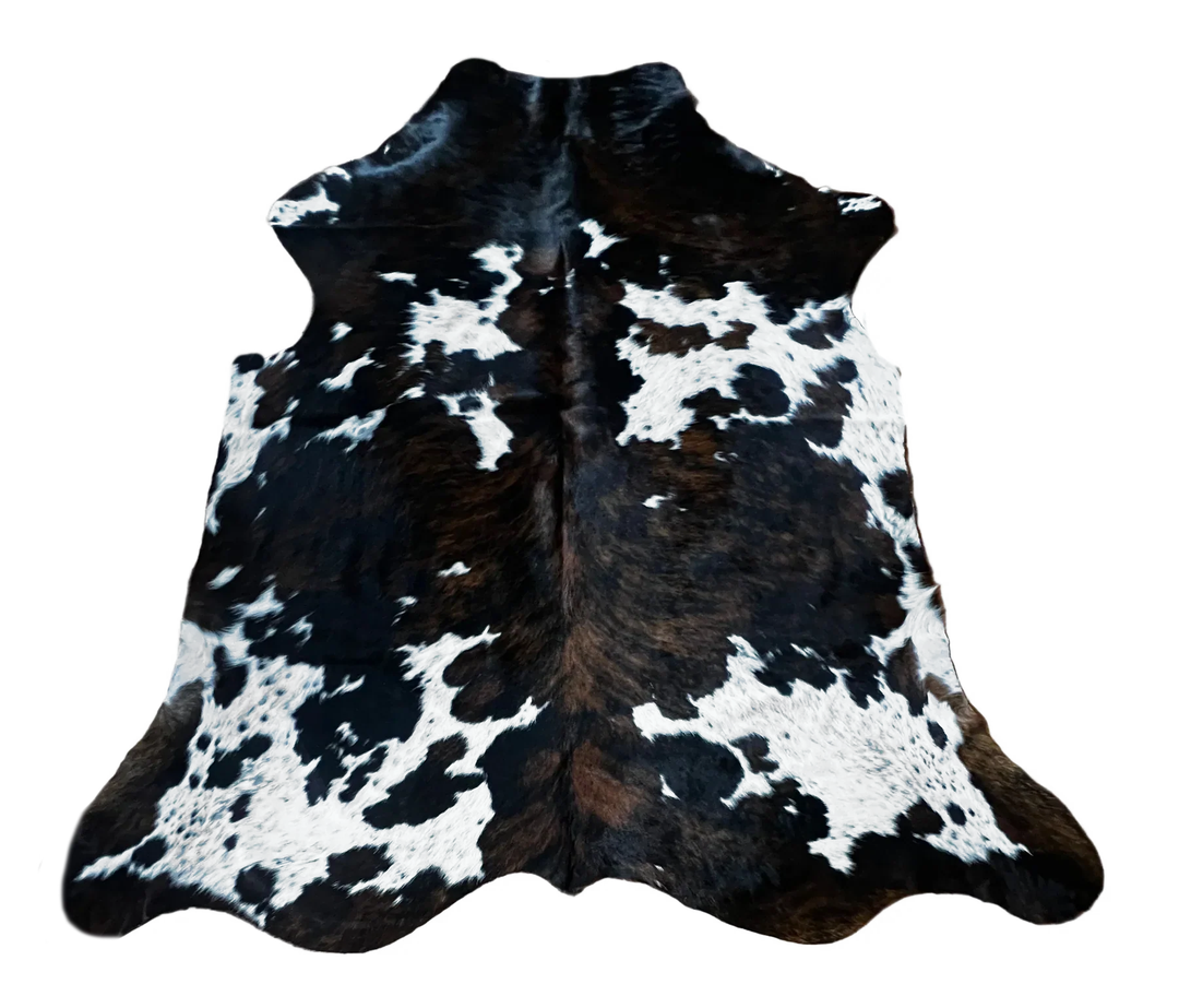 A black and white cowhide rug with a natural spotted pattern, 