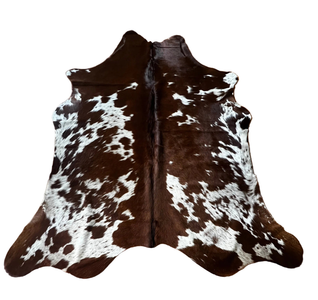 Brown and white cowhide rug shown flat against a solid white background.