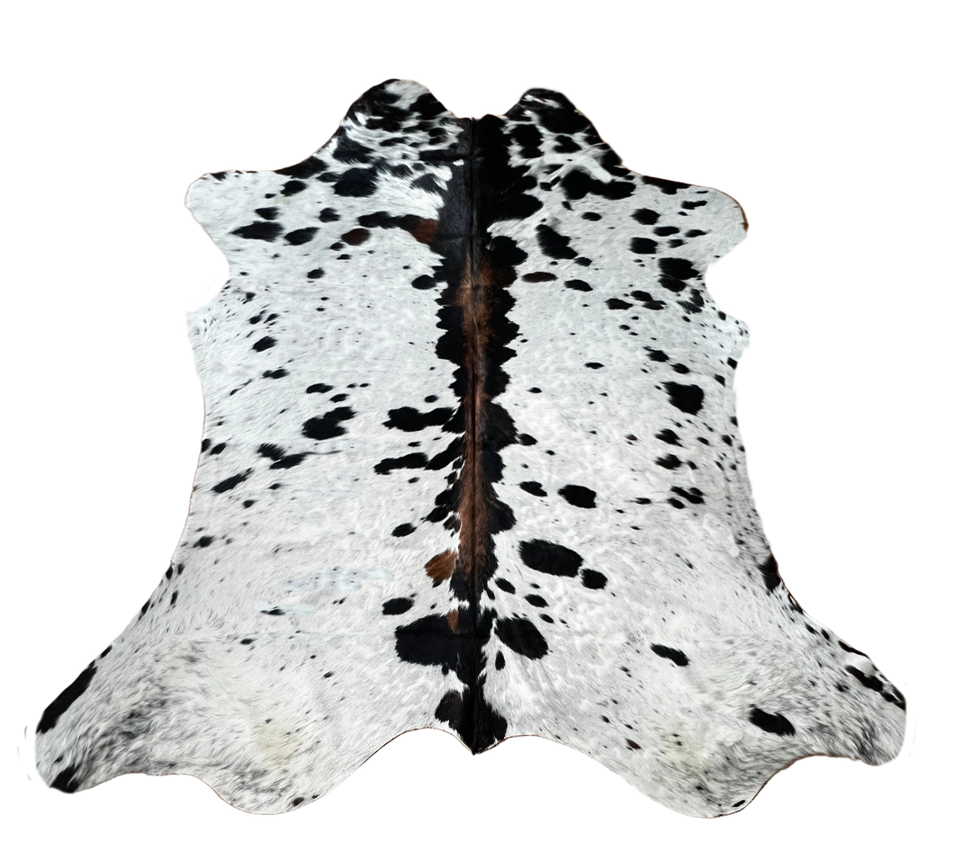 A natural black and white cowhide rug with brown undertones