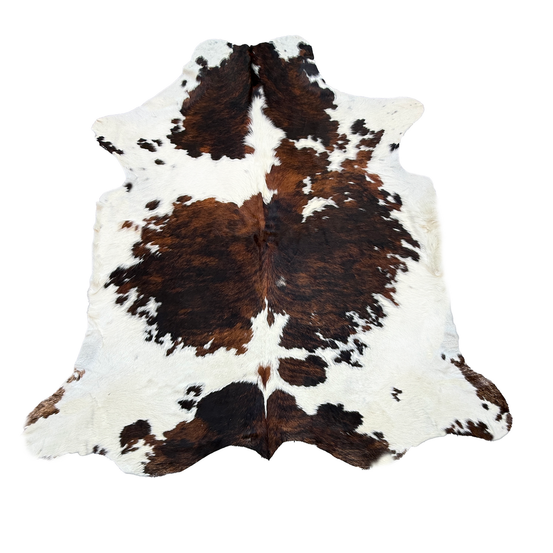 Brown and white cowhide rug on a white background