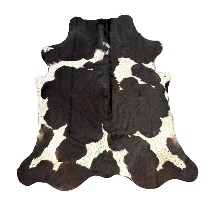 Black and white cowhide rug from Cowhide Rugs London, 192cm x 180cm, showcasing natural animal hide pattern and texture.