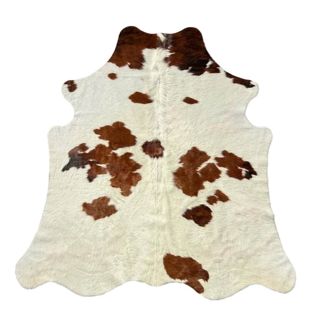 A natural cowhide rug with brown and cream patches
