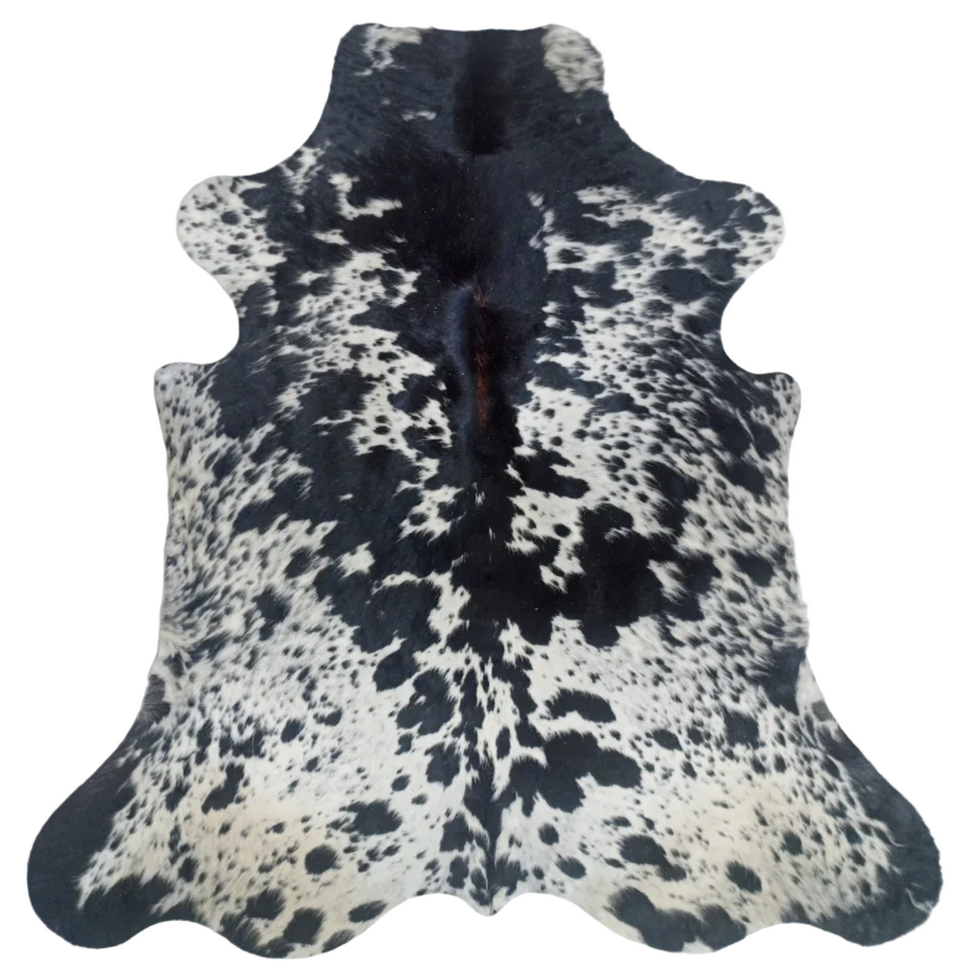 A natural black and white cowhide rug laid flat 
