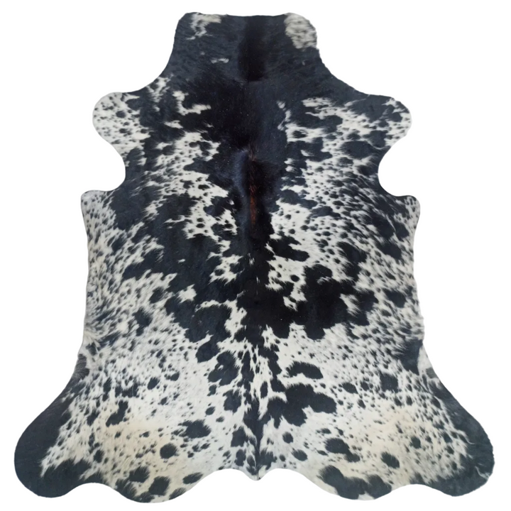 A natural black and white cowhide rug laid flat 