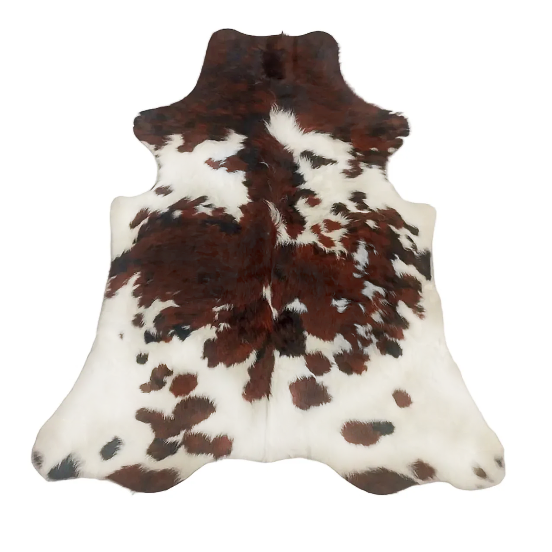Brown and white cowhide rug on a white background