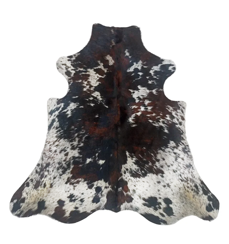 A cowhide rug with a natural black, white, and brown mottled pattern, displayed flat against a solid white background.